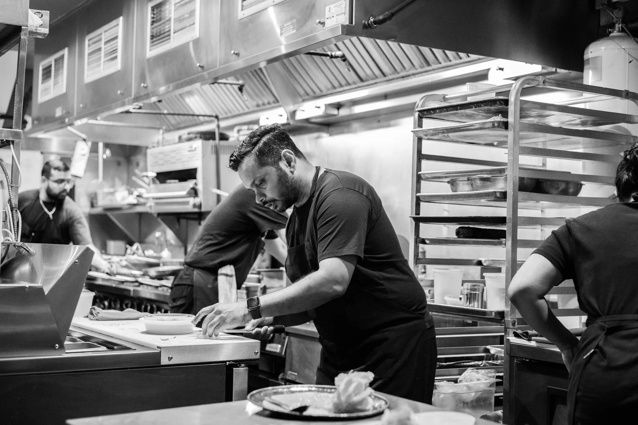 Chefs working in a busy restaurant kitchen.
