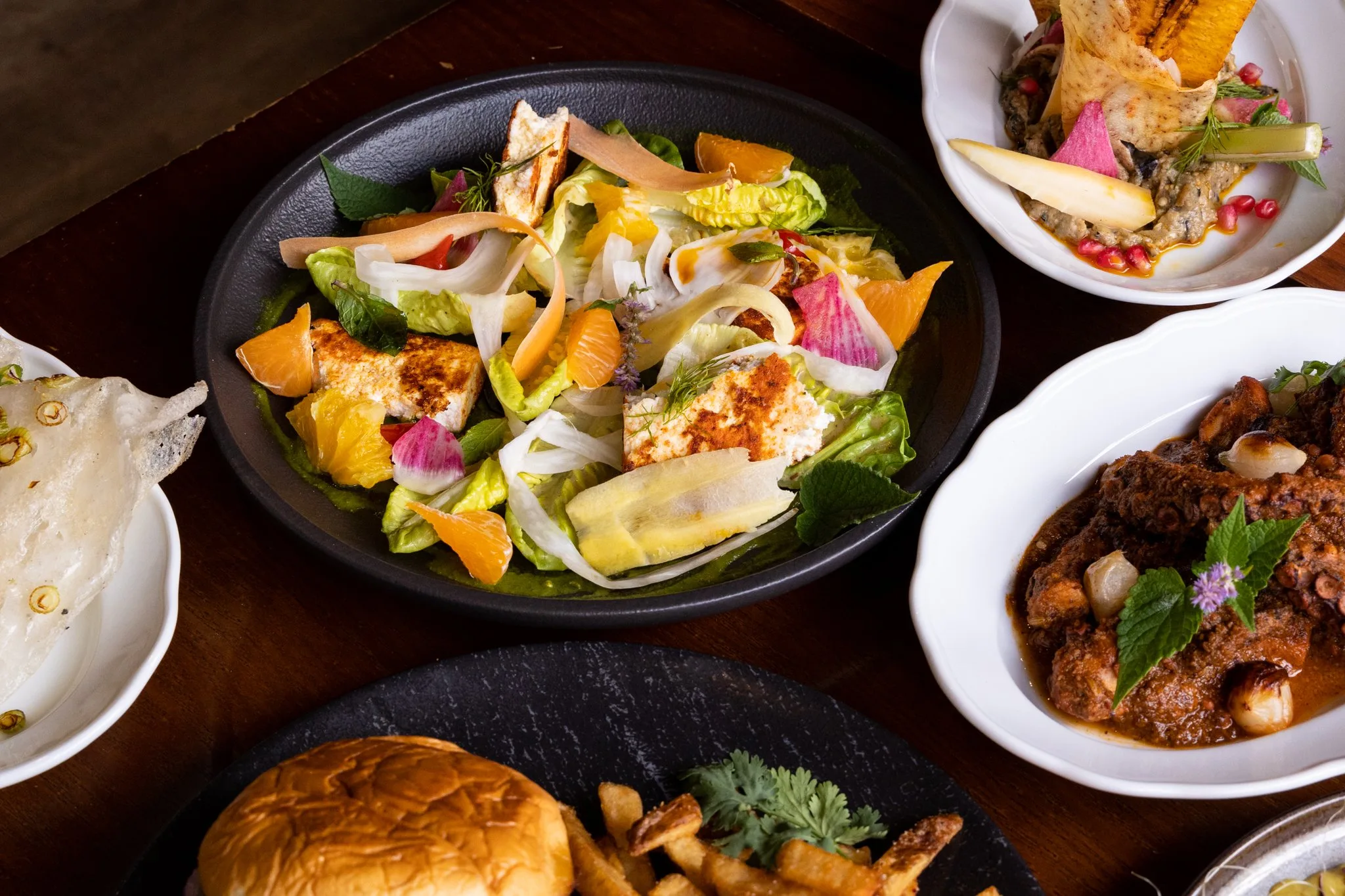 A colorful salad with citrus and creamy toppings.