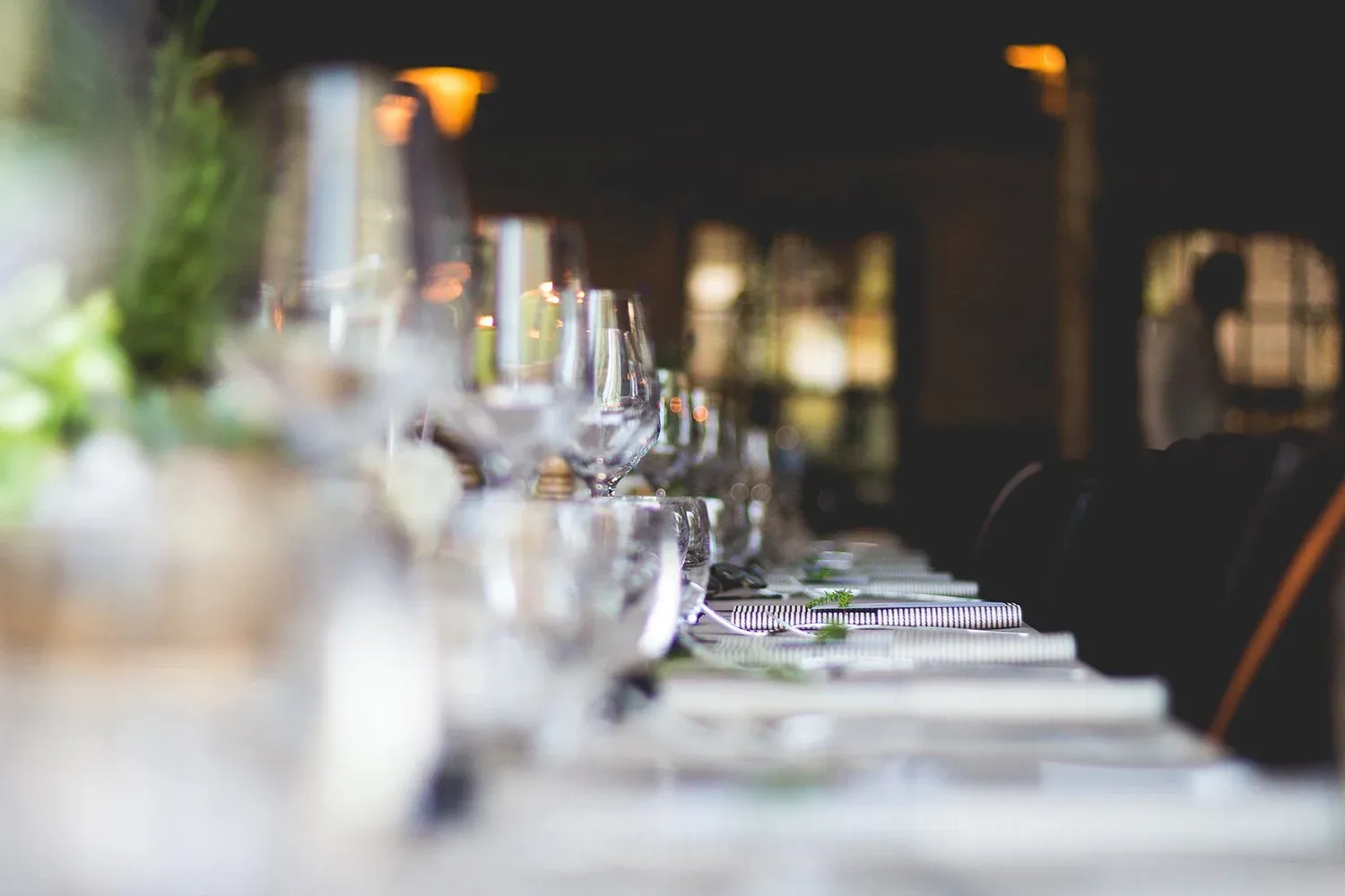 An elegantly set dining table with glasses and decor.