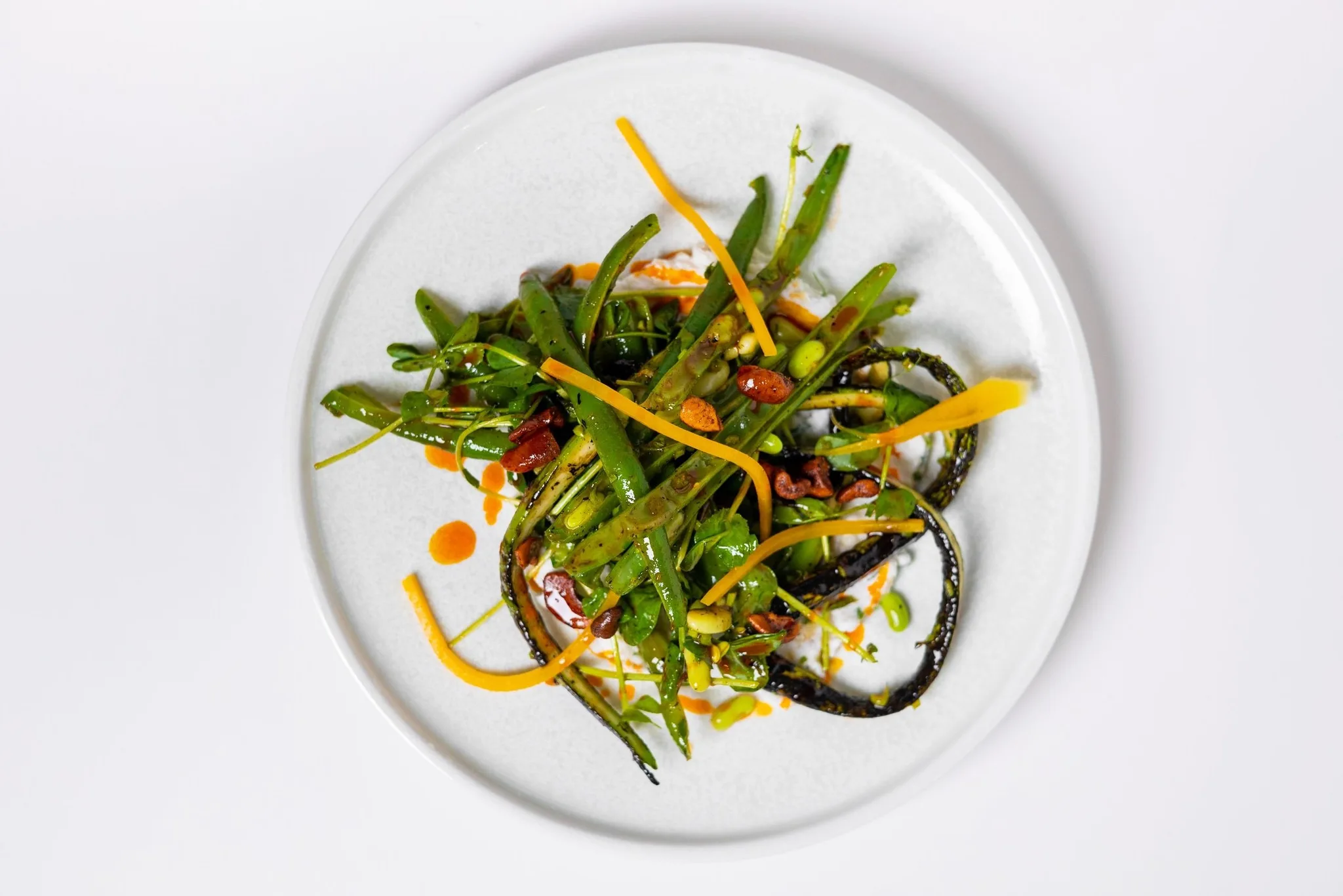 A plate of green beans and okra with sauce.