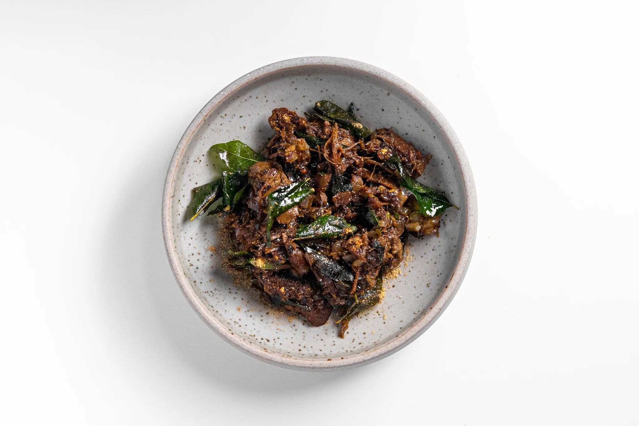A bowl of spicy Indian curry with herbs