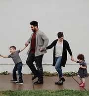 Family of four walking along a path together.