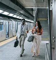 Two professionals walking together in a subway station.