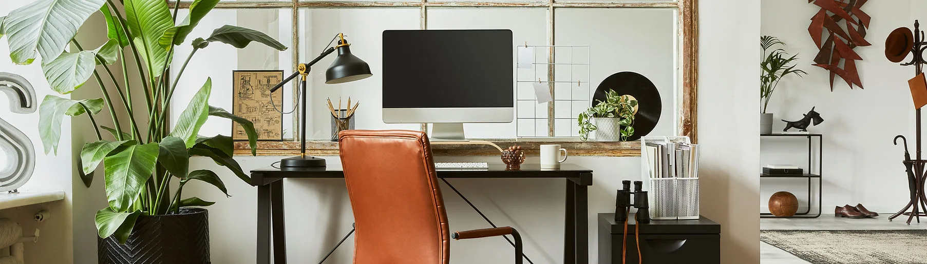 An organized workspace with a computer and plants.