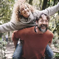 Happy couple in a green outdoor setting.
