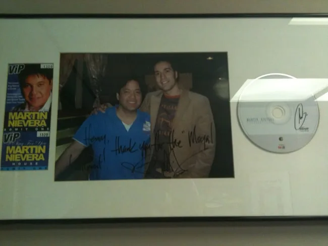 Framed photo of two individuals with signed memorabilia.