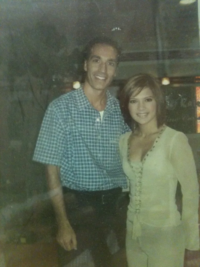 A man and a woman posing together indoors.