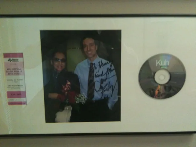 Framed photo of a man and woman with a CD and ticket stub