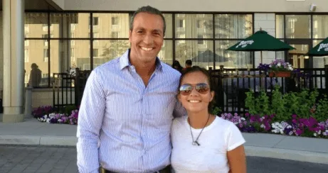 Henry Moyal with a young girl outdoors.