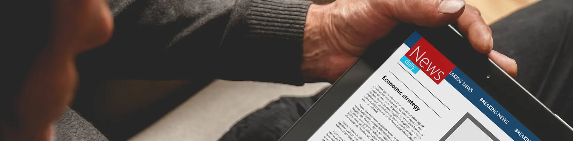 Tablet displaying a news article titled 'Economic Ideology'.