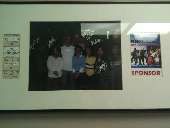 Group photo with signed memorabilia in a framed display.