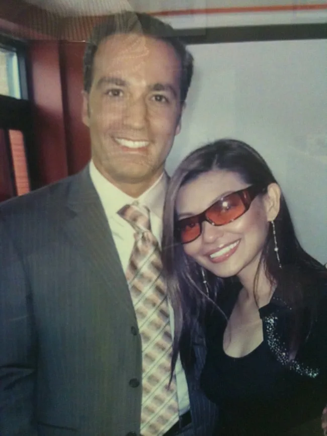 A man and woman smiling together in formal attire.