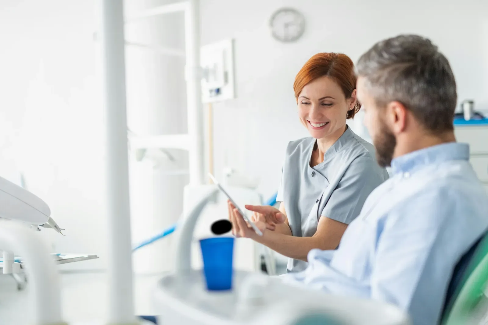 Dental hygienist discussing with a patient in a clinic.