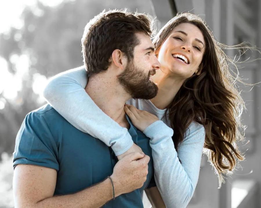 A couple embracing and smiling outdoors.