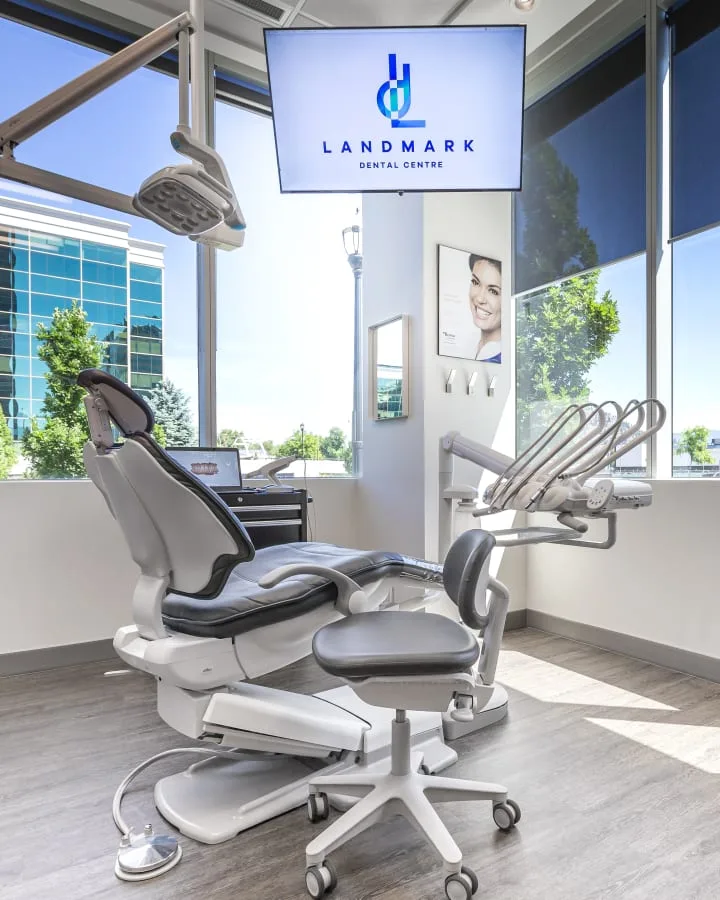 A modern dental treatment room with equipment and logo display.