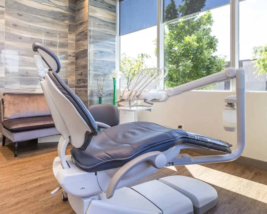A modern dental operatory with a navy blue dental chair.