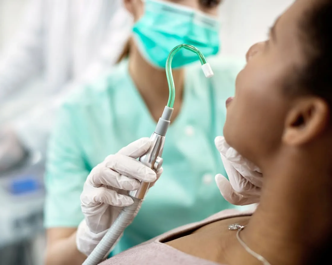 A dental hygienist cleaning a patient's teeth.