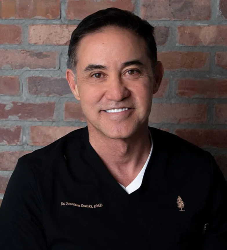 Dr. Jonathan Suzuki smiling in a dental office.