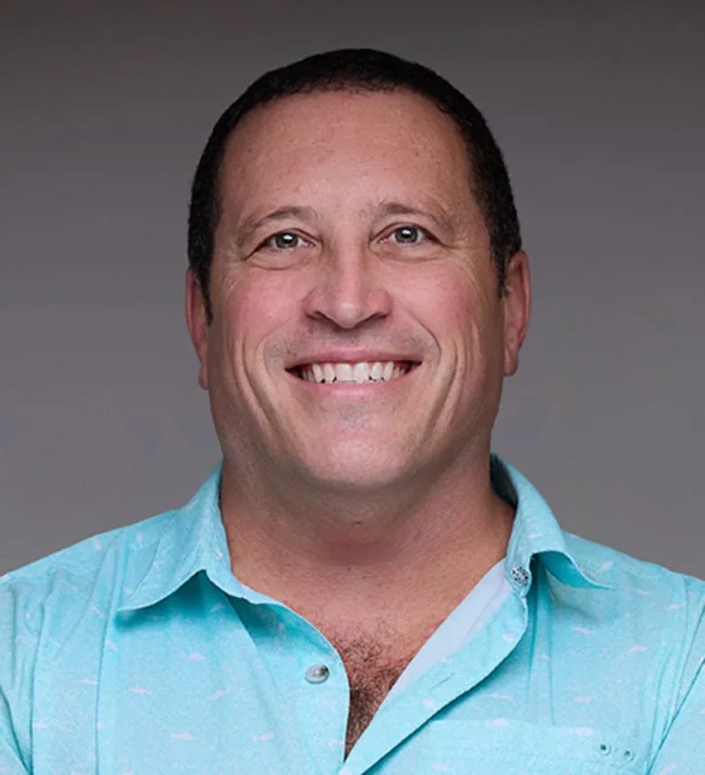 A smiling man in a light blue shirt
