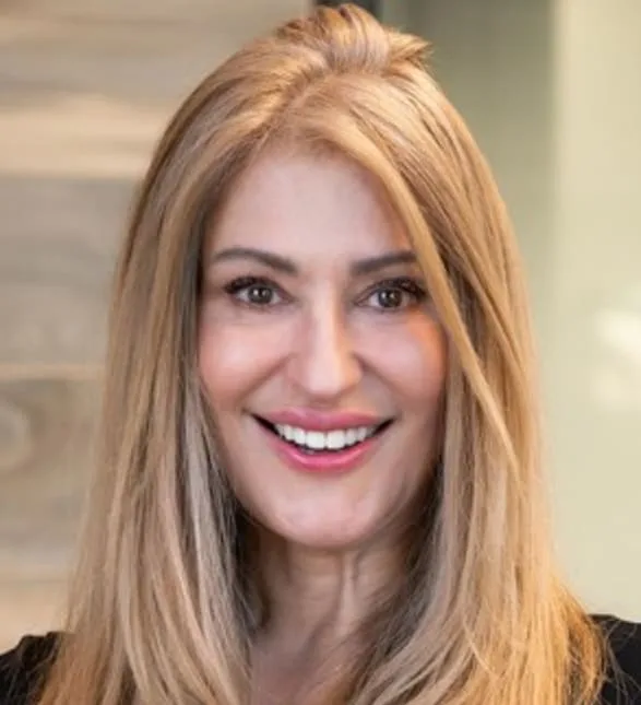 A smiling woman with blonde hair in a professional setting.