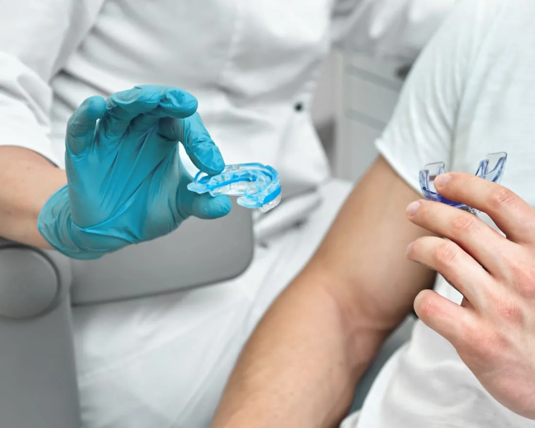 A dental professional and patient with clear dental appliances.