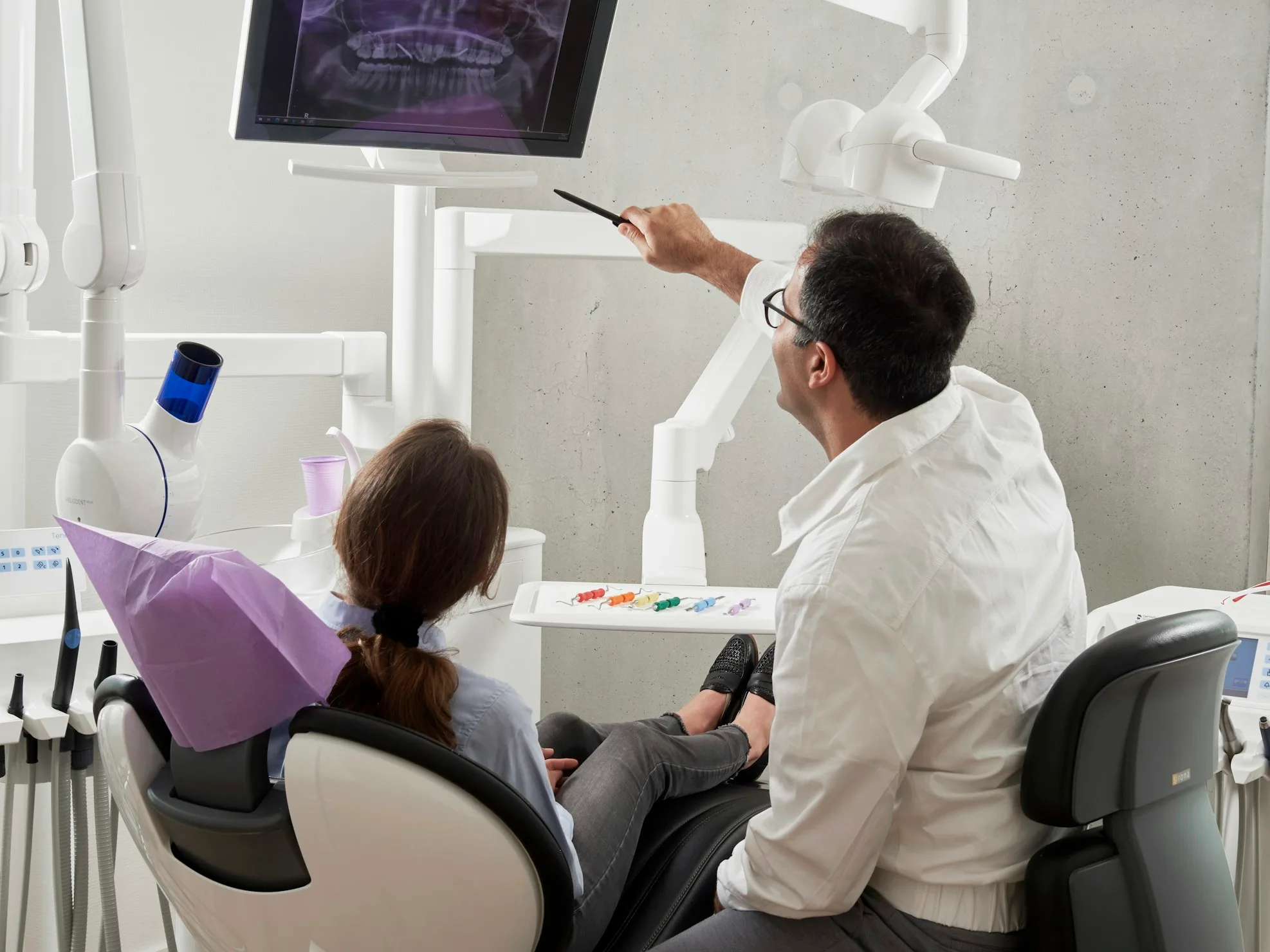 A dentist showing an X-ray to a patient in a dental office.