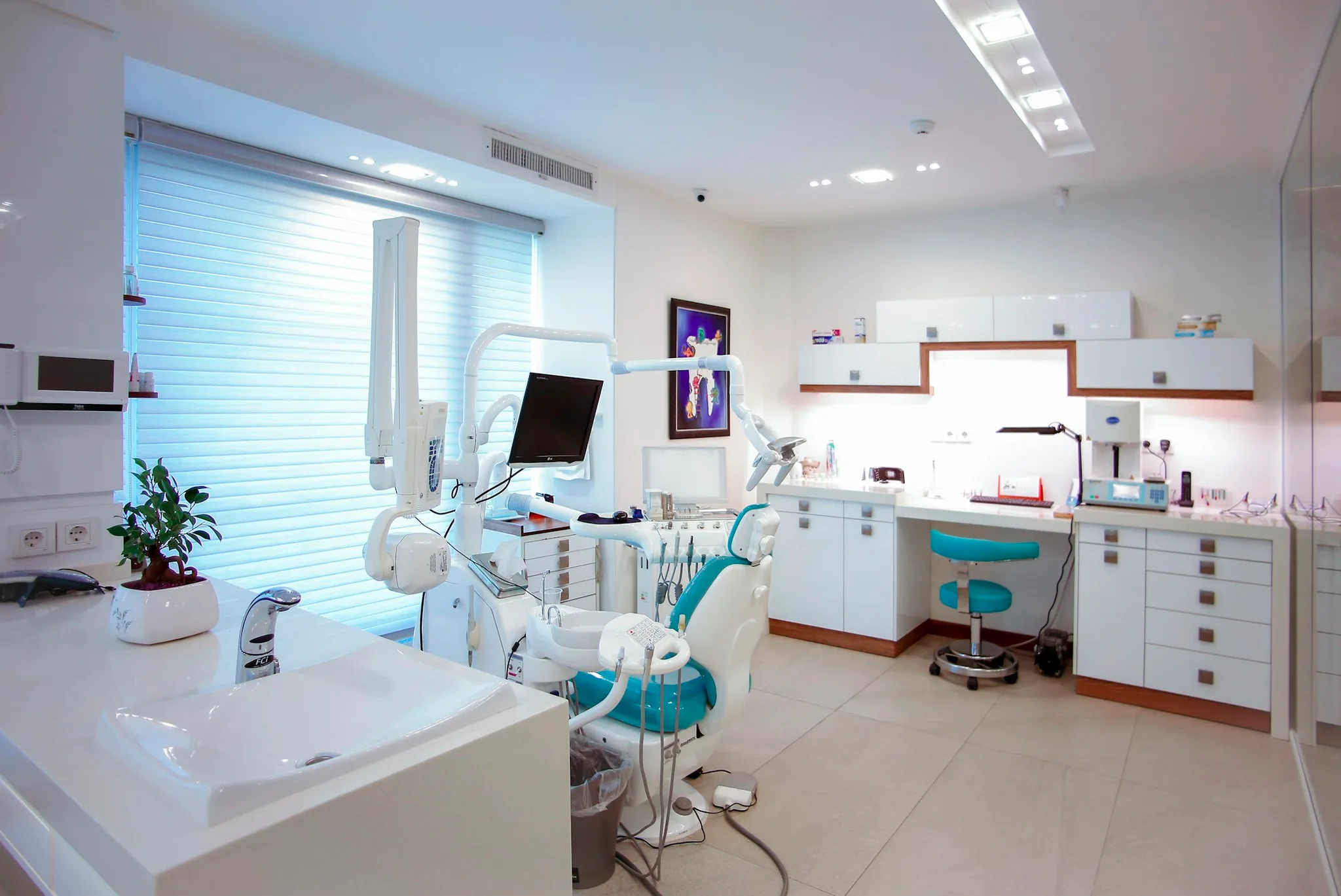 Modern dental clinic with chair and equipment.