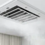 Ceiling air vent releasing air in a bright room.