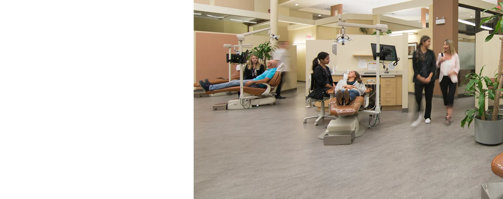 Interior of a modern dental clinic with patients and staff.