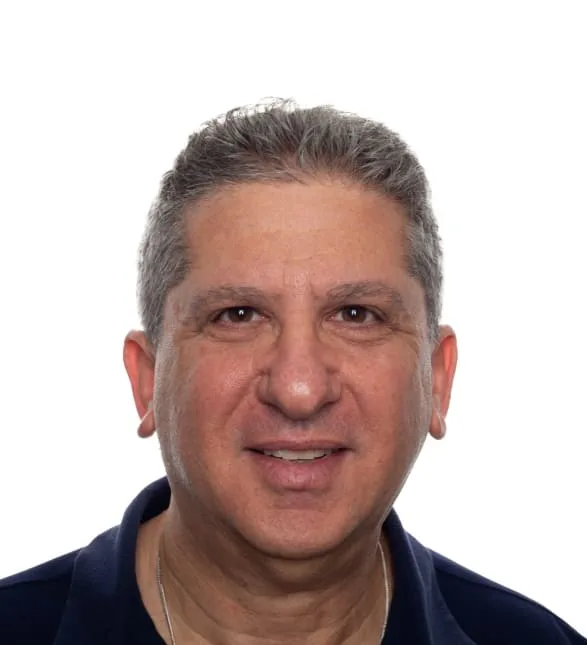 A friendly middle-aged man smiling on a plain background.