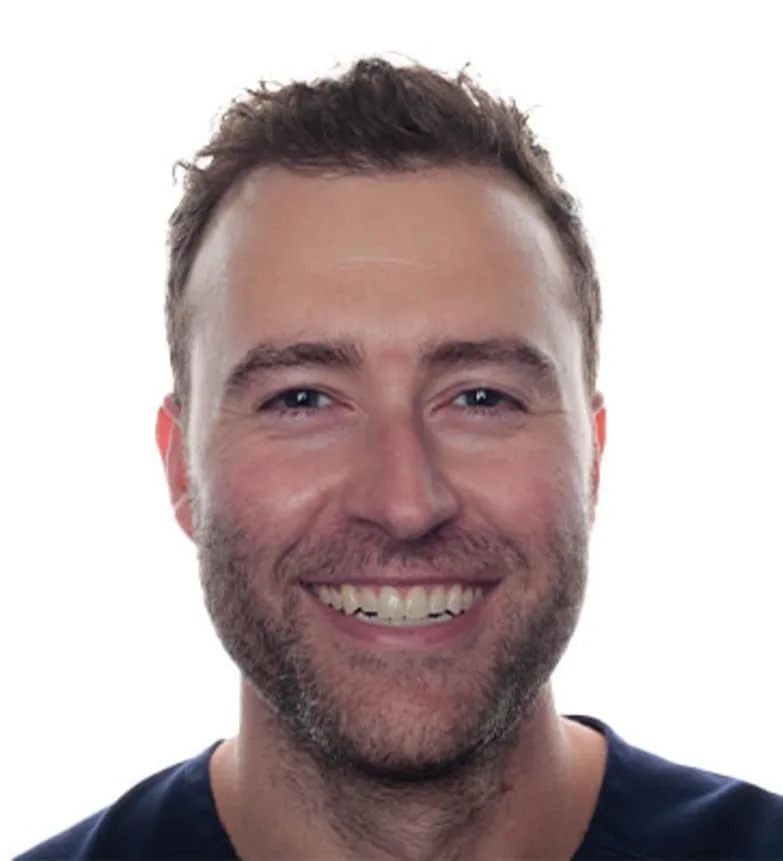 Smiling dentist in a dark blue scrub top