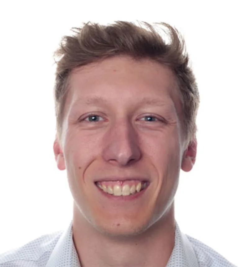 A smiling young man in a white shirt.
