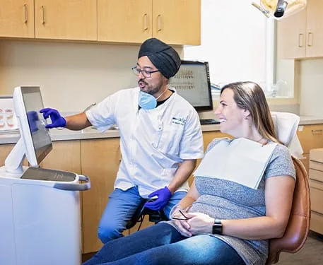 Dentist explaining treatment to a patient in a dental office.
