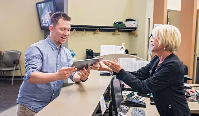Two staff members interacting at a dental office reception.