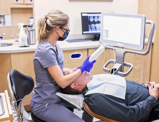 A dental hygienist performing treatment on a patient in a clinic.