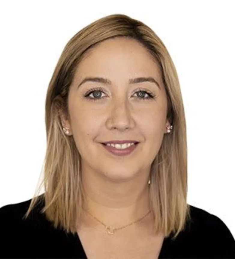 A smiling woman with blonde hair and a black top.