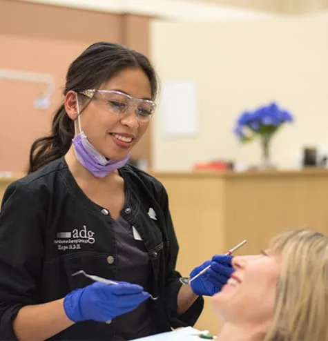 A dental hygienist servicing a patient in a clinic.