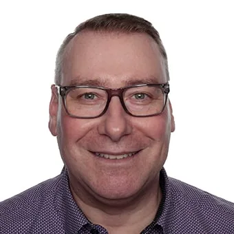 Smiling man with glasses in a button-up shirt