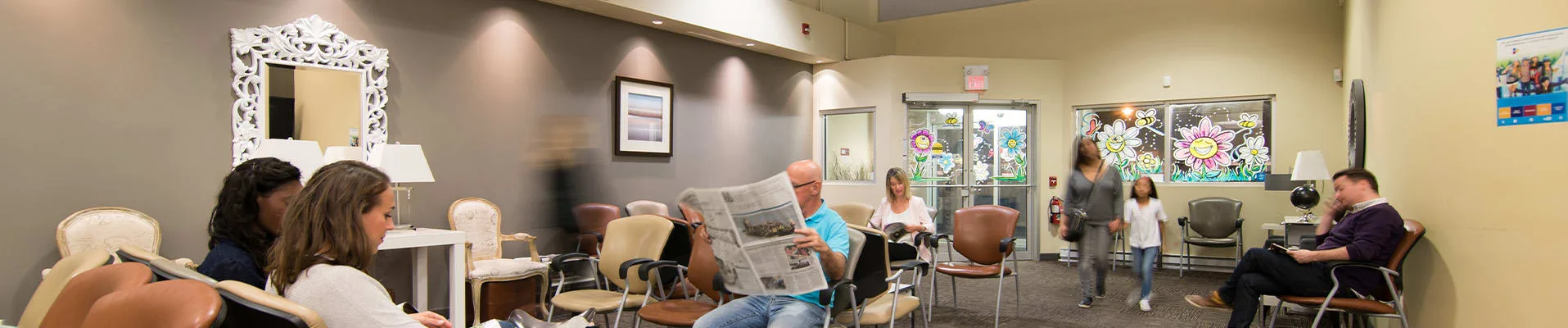A dental clinic waiting area with patients and modern decor.