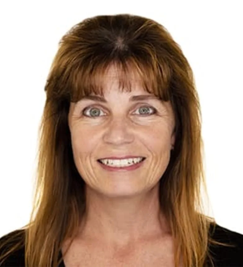 A smiling woman with brown hair in a dark top.