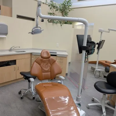 A dental treatment room with brown chair and equipment.