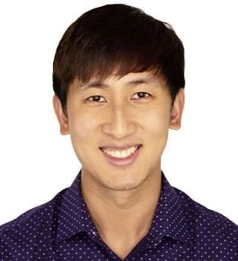 Smiling dentist in casual attire with polka dot shirt.