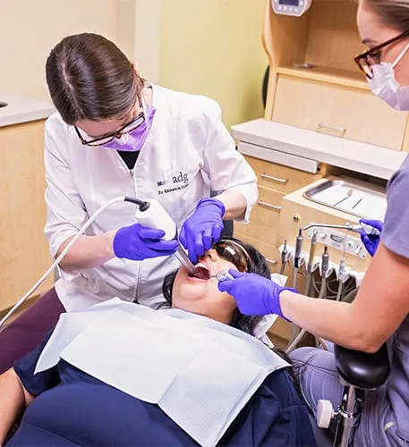 Dental professionals treating a patient in a clinic.