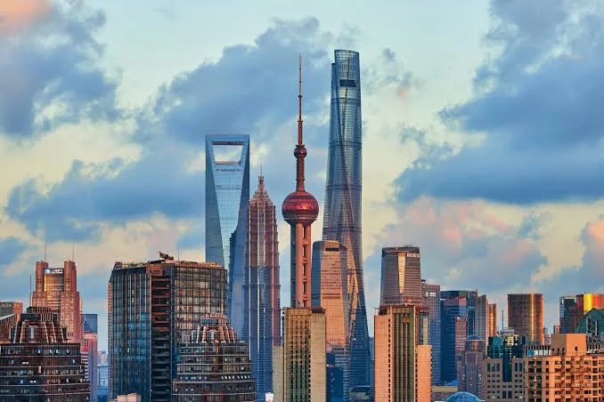 Shanghai skyline featuring iconic skyscrapers at sunset.