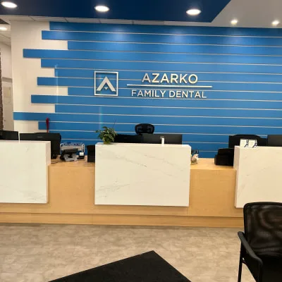 Modern dental reception area with blue accents and marble desk.
