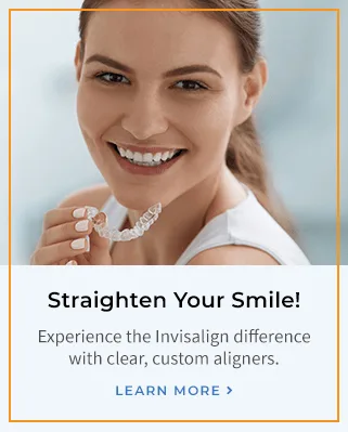 A woman smiling with a clear dental aligner in hand.