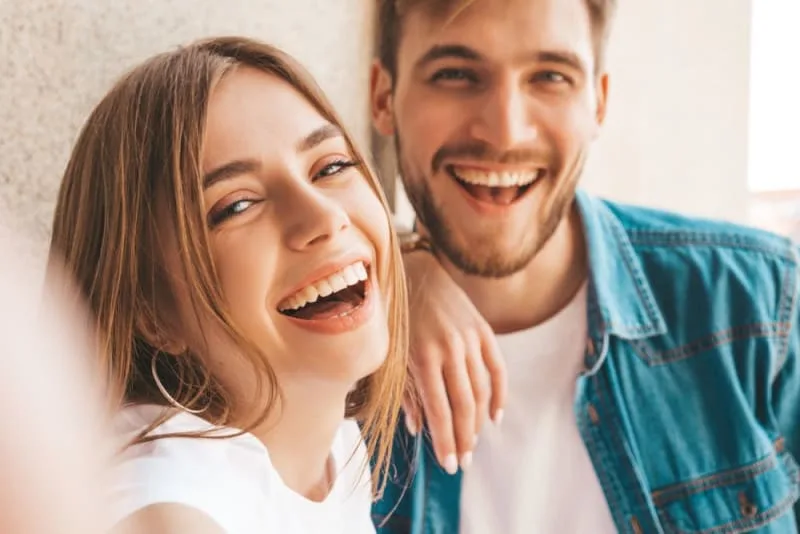 A young couple smiling together in a casual setting.