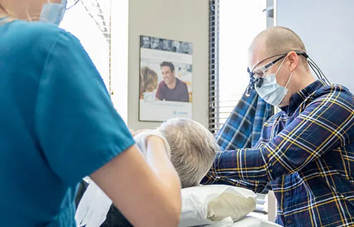 A dental professional assisting a patient in a clinic.