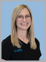 Smiling woman in a black shirt with glasses against a blue background.