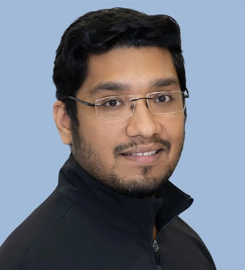 A smiling man in a black jacket with glasses.